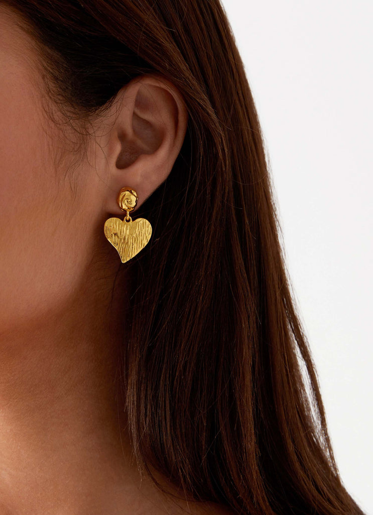 Womens Commitment Heart Earrings in the colour Gold in front of a light grey background