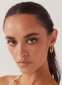 Womens Stardust Hoop Earrings in the colour Gold in front of a light grey background