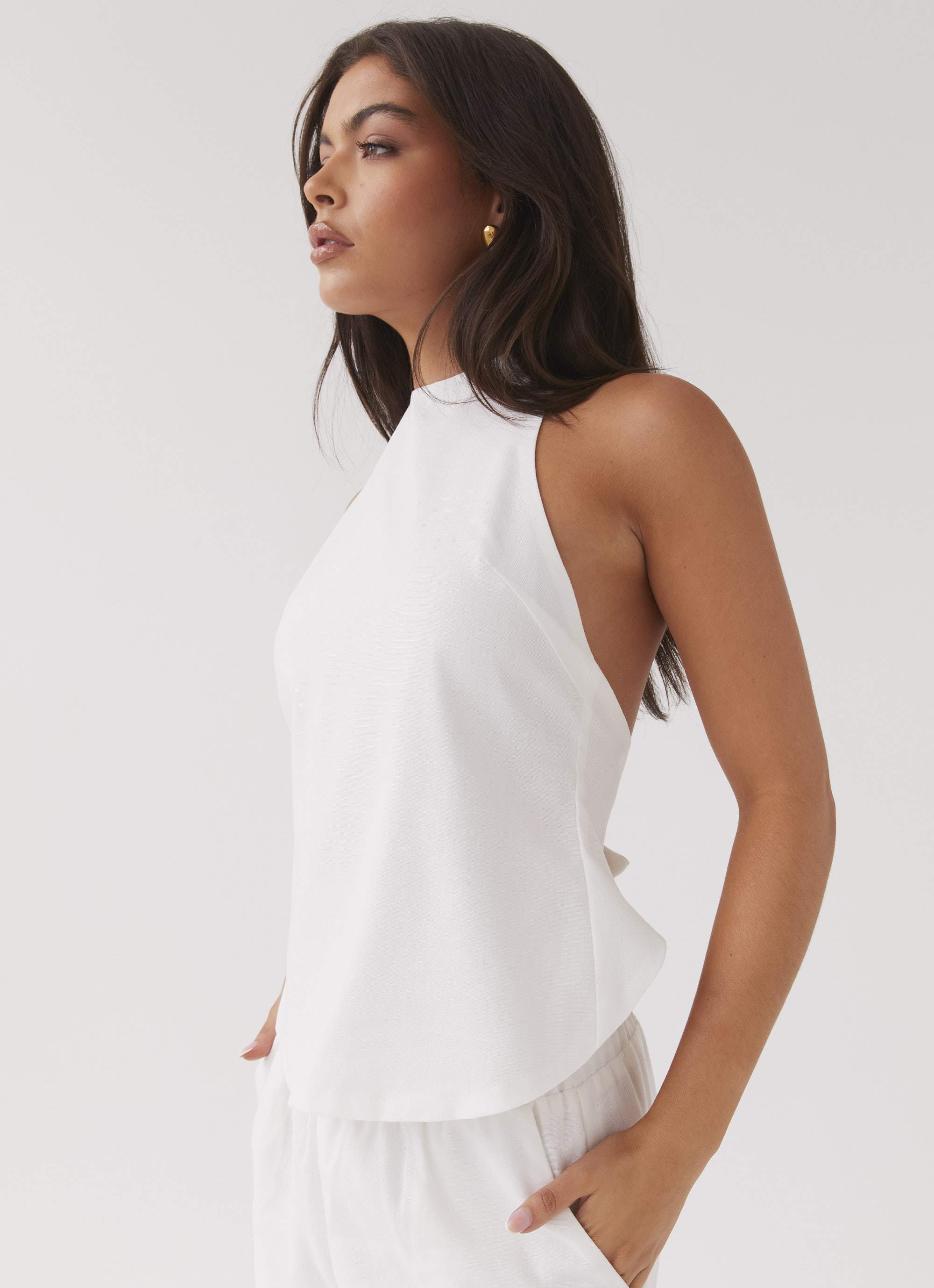 Close-up of a white linen apron top, showcasing its textured weave and natural fiber structure